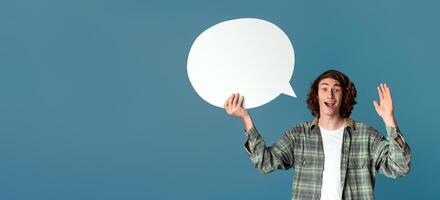 Cool guy holding speech bubble and waving on turquoise background, blank space photo