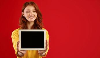 Cheerful Girl Showing Digital Tablet Empty Screen Smiling To Camera Standing On Green Background In Studio. Copy Space, Mockup photo
