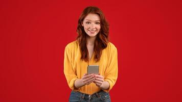 Mobile App. Happy Red-Haired Girl Using Smartphone Application Standing On Green Background. Studio Shot, Panorama photo