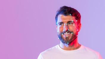 A young man with a beard smiles while facial recognition markers illuminate his face. The colorful background enhances the modern technology theme, creating a vibrant atmosphere. photo