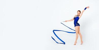 Smiling young sportswoman with gymnastic ribbon practicing on white background photo
