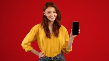 Millennial Girl Showing Cellphone Empty Screen Recommending Mobile App Posing On Green Studio Background. Mockup, Panorama photo