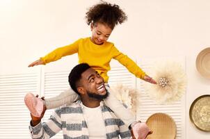 African american dad holds daughter on his shoulders, free space. Stay with family at home during quarantine photo