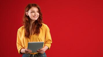 Educational App. Smiling Student Girl Holding Digital Tablet Looking Aside Standing On Green Studio Background. Panorama, Empty Space For Text photo