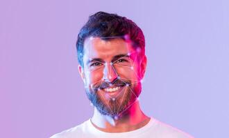 A smiling man is illuminated with colorful lights, showcasing facial recognition patterns on his face. This image highlights the intersection of technology and human expression. photo