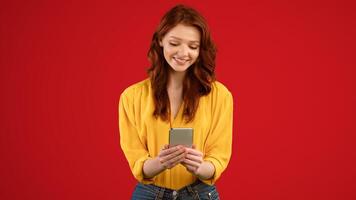 Millennial Girl With Mobile Phone Using Application Playing Online Game Standing Over Green Background. Studio Shot, Panorama photo