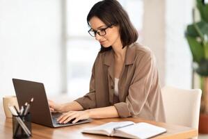 Making New Project. Portrait of satisfied girl in eyeglasses using laptop, working at home, writing blog, free space photo