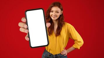 Millennial Girl Showing Cellphone Empty Screen Recommending Mobile App Posing On Green Studio Background. Mockup, Panorama photo