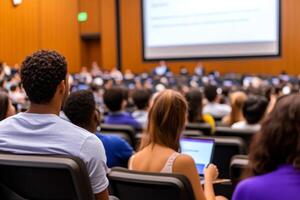 A group of diverse university students attentively listen to a lecture in a large hall. photo