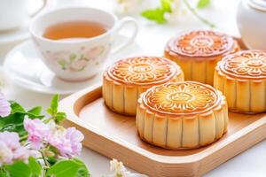 A peaceful tea setting with four beautifully designed traditional Chinese mooncakes on a wooden tray photo
