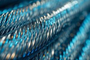 Close-up of smooth, coiled steel wire in cool metallic tones, reflecting soft light photo