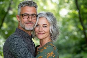 A happy couple embracing in a lush green park during a sunny day in early summer photo