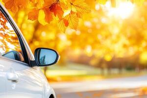 Sunset view from a car window showcasing an autumn landscape with golden sunlight in the distance photo