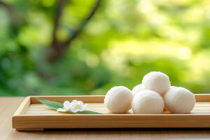 Sweet coconut balls arranged on a bamboo tray with warm morning light in a Japanese inspired setting photo