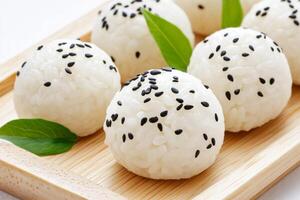 Elegant white rice balls adorned with black sesame seeds in a minimalist Japanese cuisine setting photo