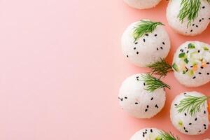 Delicate temari rice balls adorned with seaweed and vegetables on a soft pastel background photo