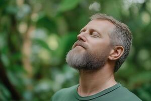 A man experiences deep relaxation in a serene green forest while practicing mindfulness and connecting with nature photo