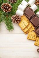 Cozy smores setup on a rustic wooden table surrounded by pine cones and evergreen branches for the holidays photo