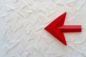 Red arrow illustrating the concept of contrasting directions against a backdrop of white arrows in minimalistic style photo