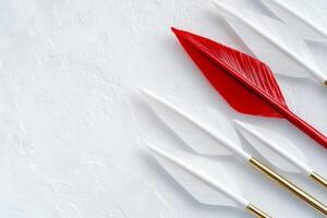A striking red arrow contrasts against white arrows, symbolizing divergence and individuality in a minimalistic design photo