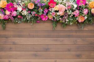 Decorative boho garden setting with a colorful flower garland arch on a rustic wooden backdrop photo