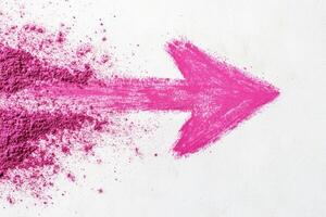 Vibrant pink arrow created with powder paint on a clean white background representing creativity and boldness photo