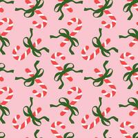 candSeamless pattern with Christmas candy canes and bows on pink background. Cute background design for fabric, wrapping paper, textile, wallpaper vector