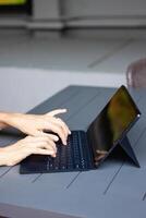 Close up of a womans hands on keyboard of lap top in the dark room, people working at home photo