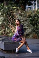 Beautiful blond young woman in long colorful dress photo