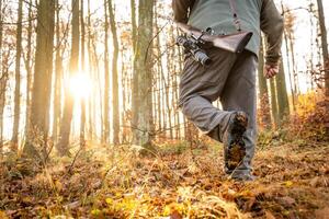 Hunter or ranger with a professional, nightvision hunting gun and hunting form to hunt in an autumn forest, hunting concept photo