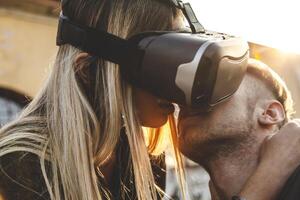 beautiful couple in love hugging with glasses of virtual reality photo