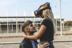 beautiful couple in love hugging with glasses of virtual reality photo