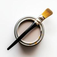 Top view of open can of paint with a brush on it, white background photo