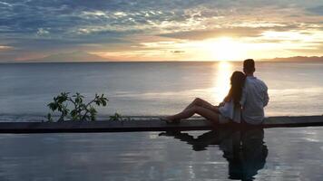 Couple In Love At Luxury Resort On Romantic Summer Vacation. People Relaxing Together In Edge Swimming Pool , Enjoying Beautiful sunset Sea View. Happy Lovers On Honeymoon Travel. Relationship video