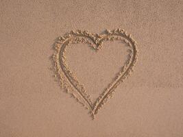 Heart shape drawn on sand photo