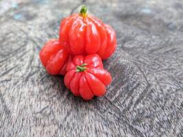 Tropical fruit. The Brazilian cherry or Pitanga also know as Eugenia uniflora, ripening on the pitangueira tree. Red fruit. photo