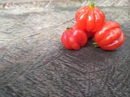 Tropical fruit. The Brazilian cherry or Pitanga also know as Eugenia uniflora, ripening on the pitangueira tree. Red fruit. photo