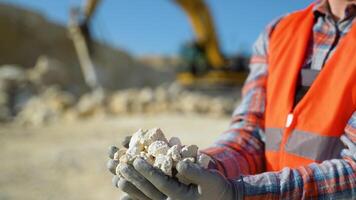 Worker engineer hold gravel in hand, checks quality at quarry, close up video