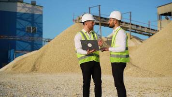 Team Engineers in hardhat use laptop to plan the work of a stone quarry video