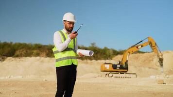 Foreman giving commands to employees using walkie talkie at quarry video