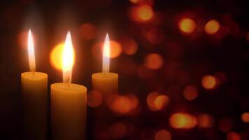 Candles in the Christmas Lights 4K Loop features three holiday candles flickering in an atmosphere of floating diffused lights in a loop. video