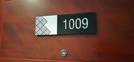Modern room number hotel with 1009 on the wall door photo