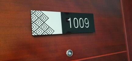 Modern room number hotel with 1009 on the wall door photo