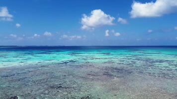 Drone view of a beach with waves on the Maldives with the dreamlike blue of the ocean and the view of the horizon. video