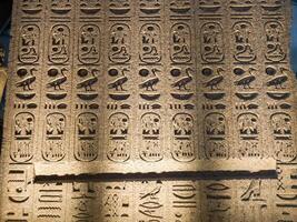 Old Egyptian hieroglyphs on an stone background. Ancient Egyptian hieroglyphs as pattern in Tombs. photo