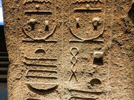Old Egyptian hieroglyphs on an stone background. Ancient Egyptian hieroglyphs as pattern in Tombs. photo