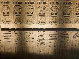 Old Egyptian hieroglyphs on an stone background. Ancient Egyptian hieroglyphs as pattern in Tombs. photo