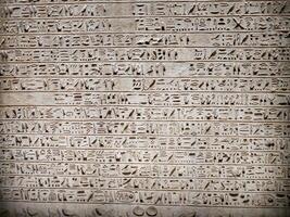 Old Egyptian hieroglyphs on an stone background. Ancient Egyptian hieroglyphs as pattern in Tombs. photo
