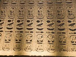 Old Egyptian hieroglyphs on an stone background. Ancient Egyptian hieroglyphs as pattern in Tombs. photo