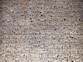 Old Egyptian hieroglyphs on an stone background. Ancient Egyptian hieroglyphs as pattern in Tombs. photo